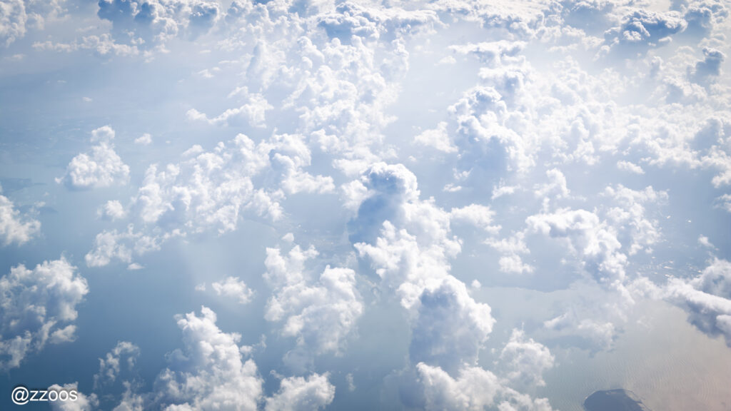 飛行機の窓の外に広がる雲の海