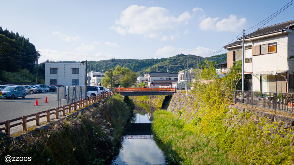 駅前を流れる小さな川と、遠くに見える小さな橋