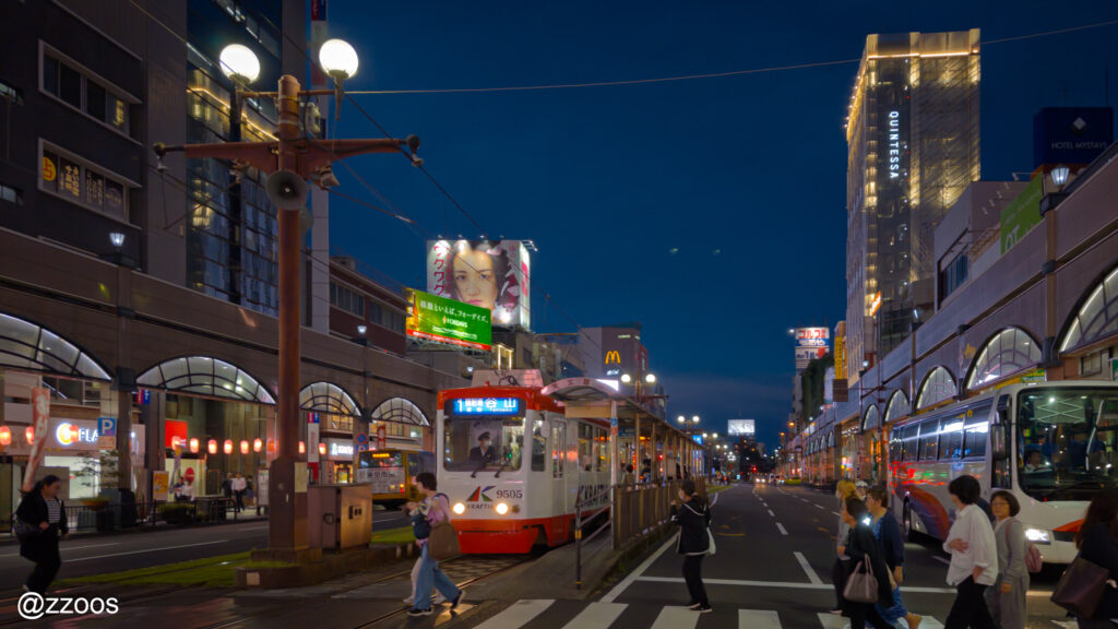 夜の鹿児島の街。天文館を走る路面電車。
