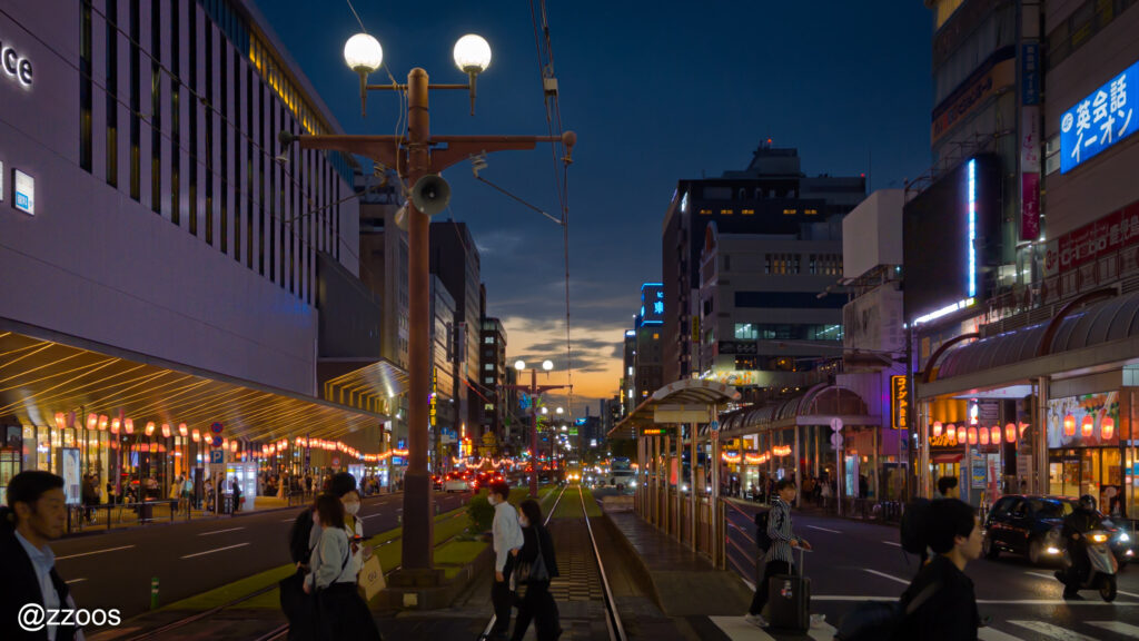 夜の天文館通で横断歩道を渡る人たち。