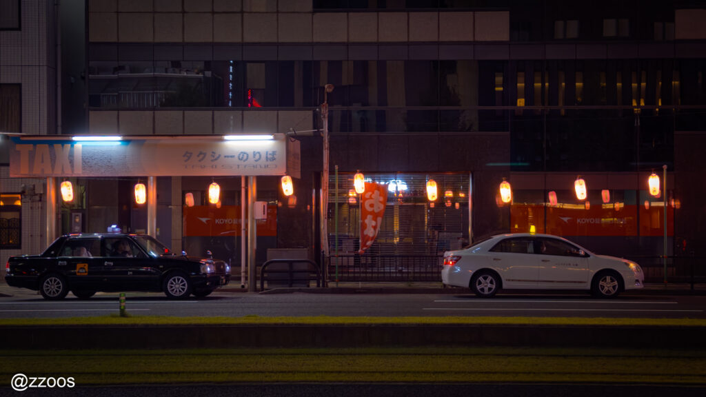 夜の鹿児島の街。客待ちをするタクシー。