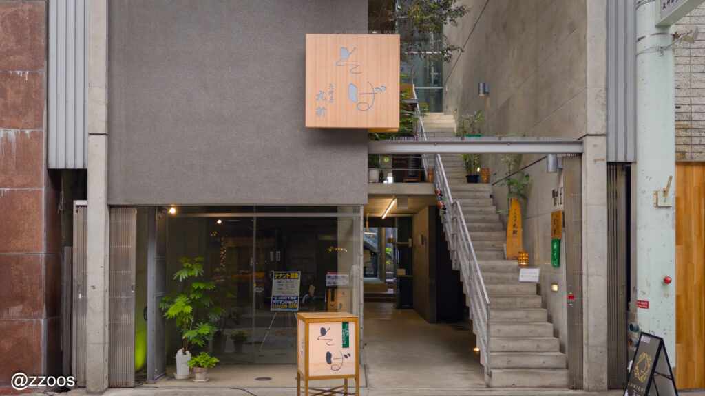 天神房 丸新の入口と店名が書かれた看板の外観。