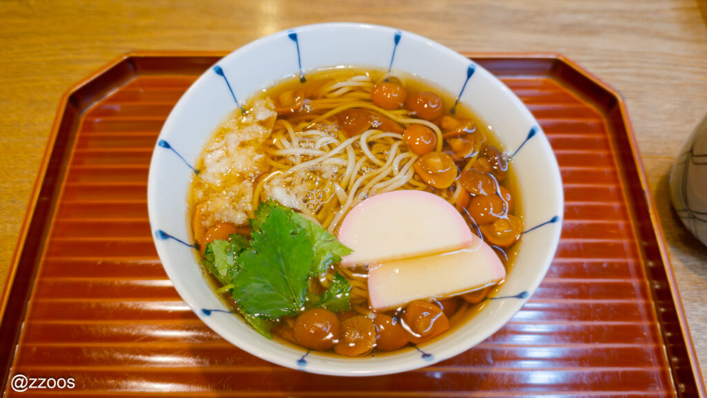 なめこ、かまぼこ、みつばがのったなめこそばのアップ。