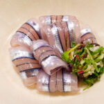 Beautifully arranged kibinago sashimi with vegetables.