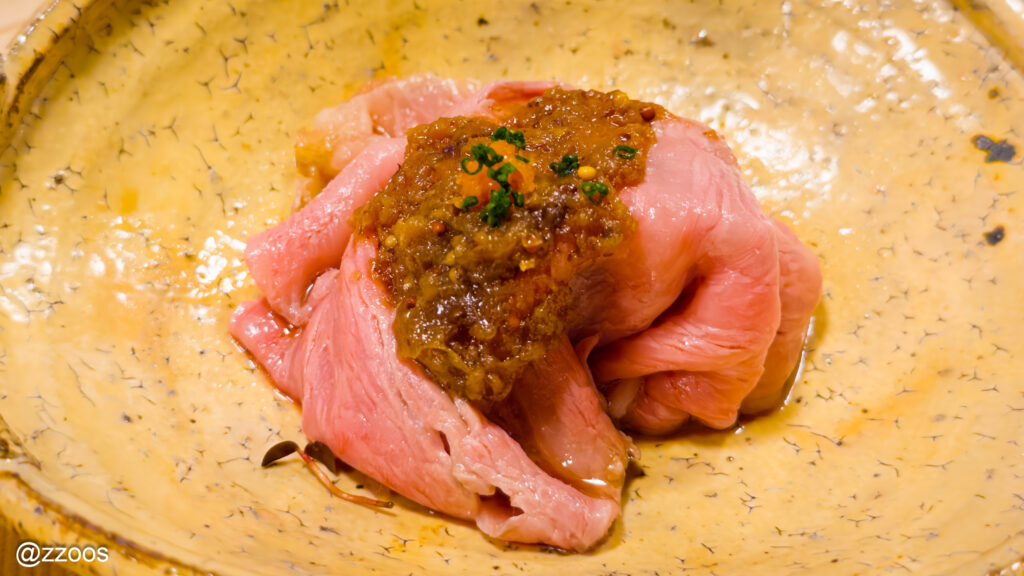 ピンク色に火入れされた、黒毛和牛のシャブシャブ一切れ