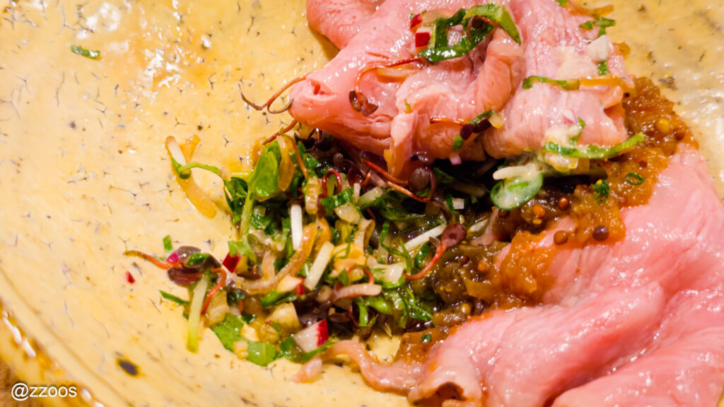 黒毛和牛の下に、細かく刻まれた野菜とソースが詰まった断面