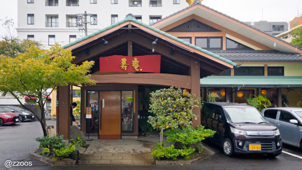 とんかつ店・寿庵の入口と看板、広い駐車場を備えた外観