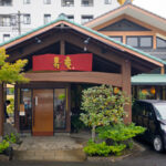 Entrance, signboard, and parking lot of Juan tonkatsu restaurant in Kagoshima