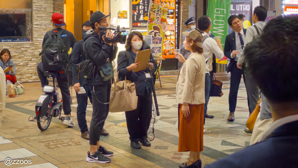 焼酎ストリート会場でインタビューを行うリポーターとテレビカメラ