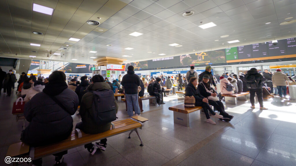ソウル駅のコンコースで電車を待つ人々
