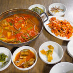 Table filled with Korean seafood dishes and side dishes