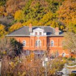 A red brick building seen through trees