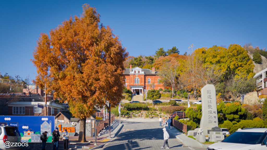 急な坂道とその先に見える赤レンガの建物