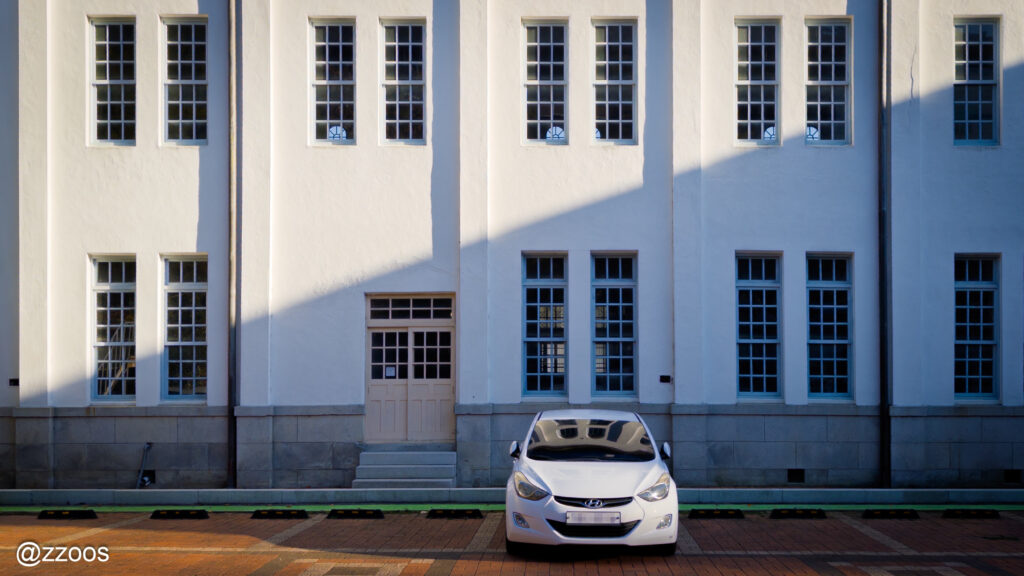 規則的な窓の上に落ちる午後の日差しと影