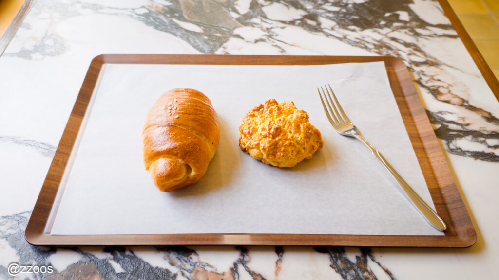 テーブルの上のトレーに置かれた塩パンとバタースコーン、そしてフォーク