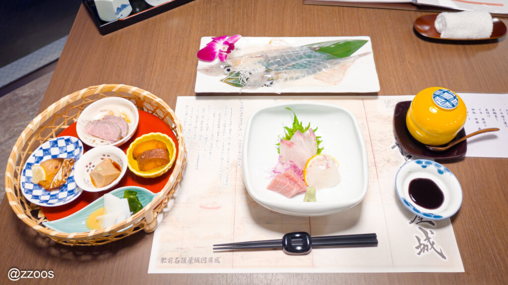Table set with appetizers, sashimi, ika ikezukuri, and chawanmushi