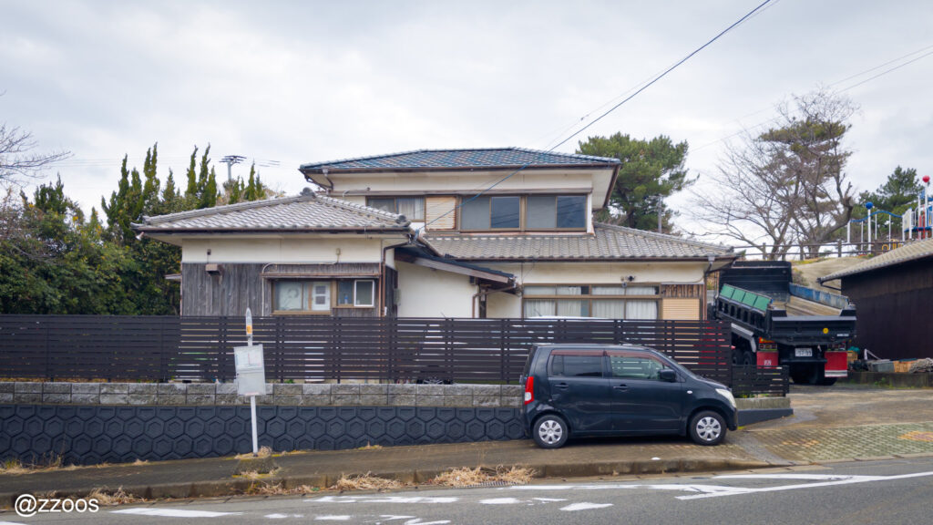 日本の伝統的な家屋の前にあるバス停