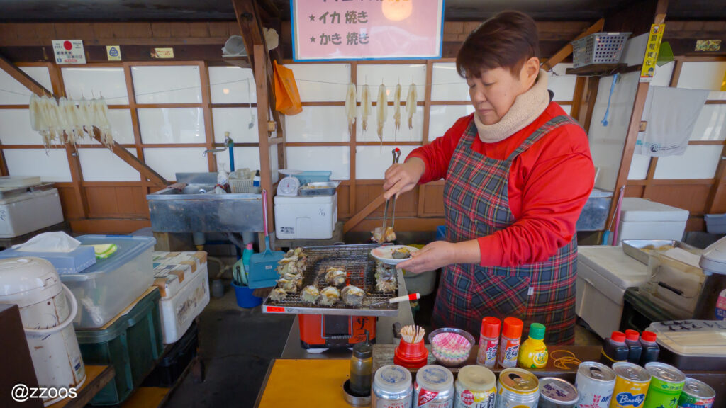 小さな炭火の上で焼かれているサザエたち。