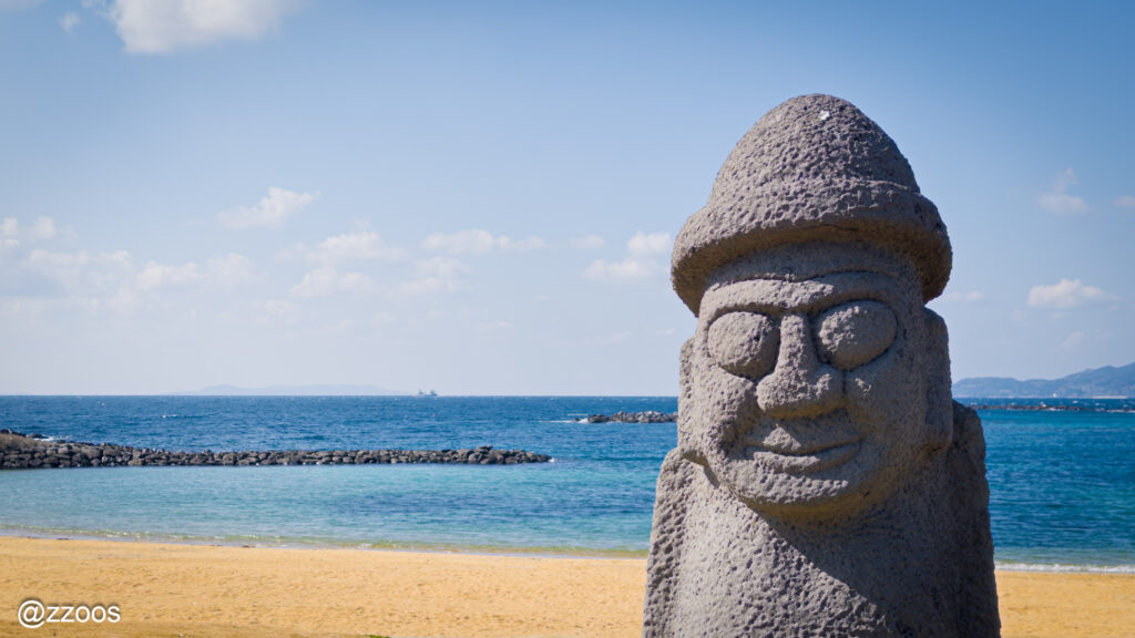 The sea at Hadomisaki Beach and a dol hareubang statue