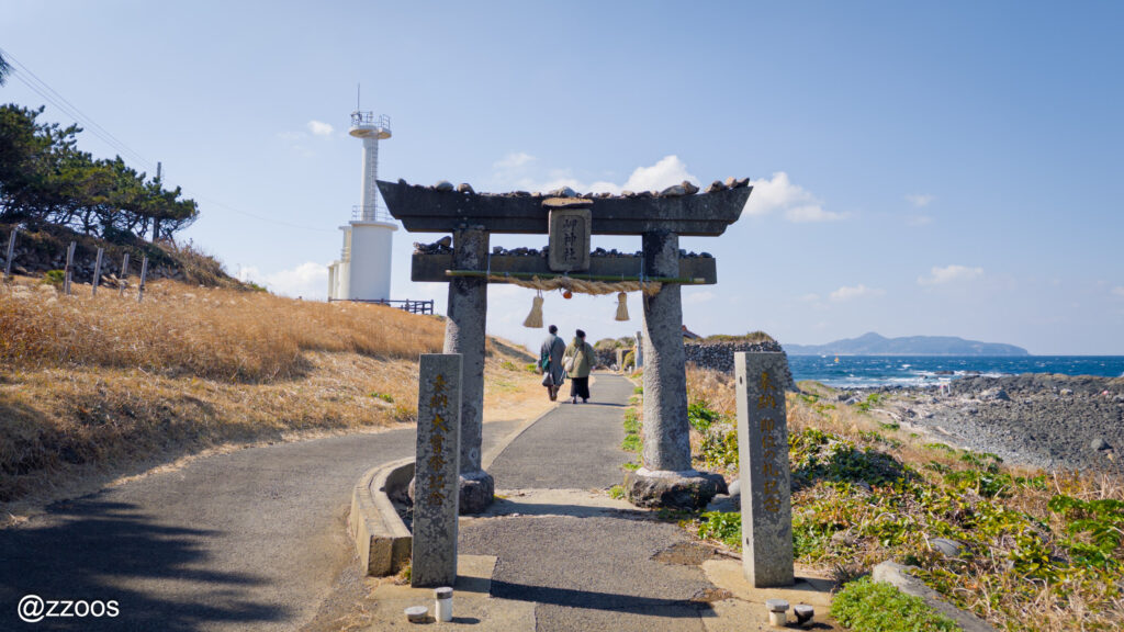The torii of Misaki Shrine, the sea, and a couple.