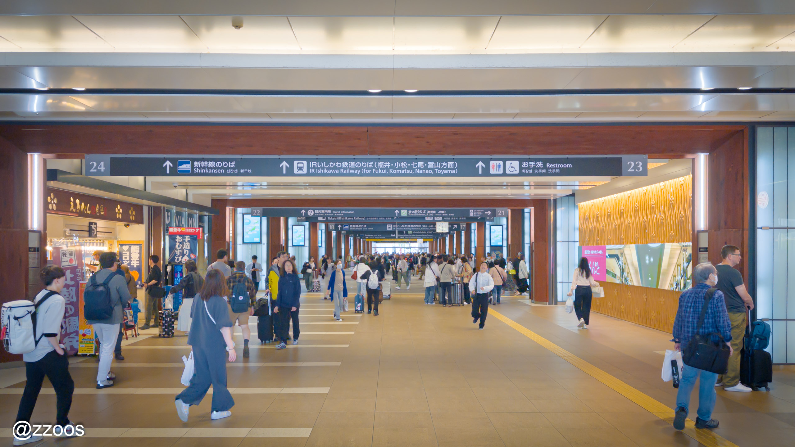 Interior of Kanazawa Station east exit area with shops and bus stops