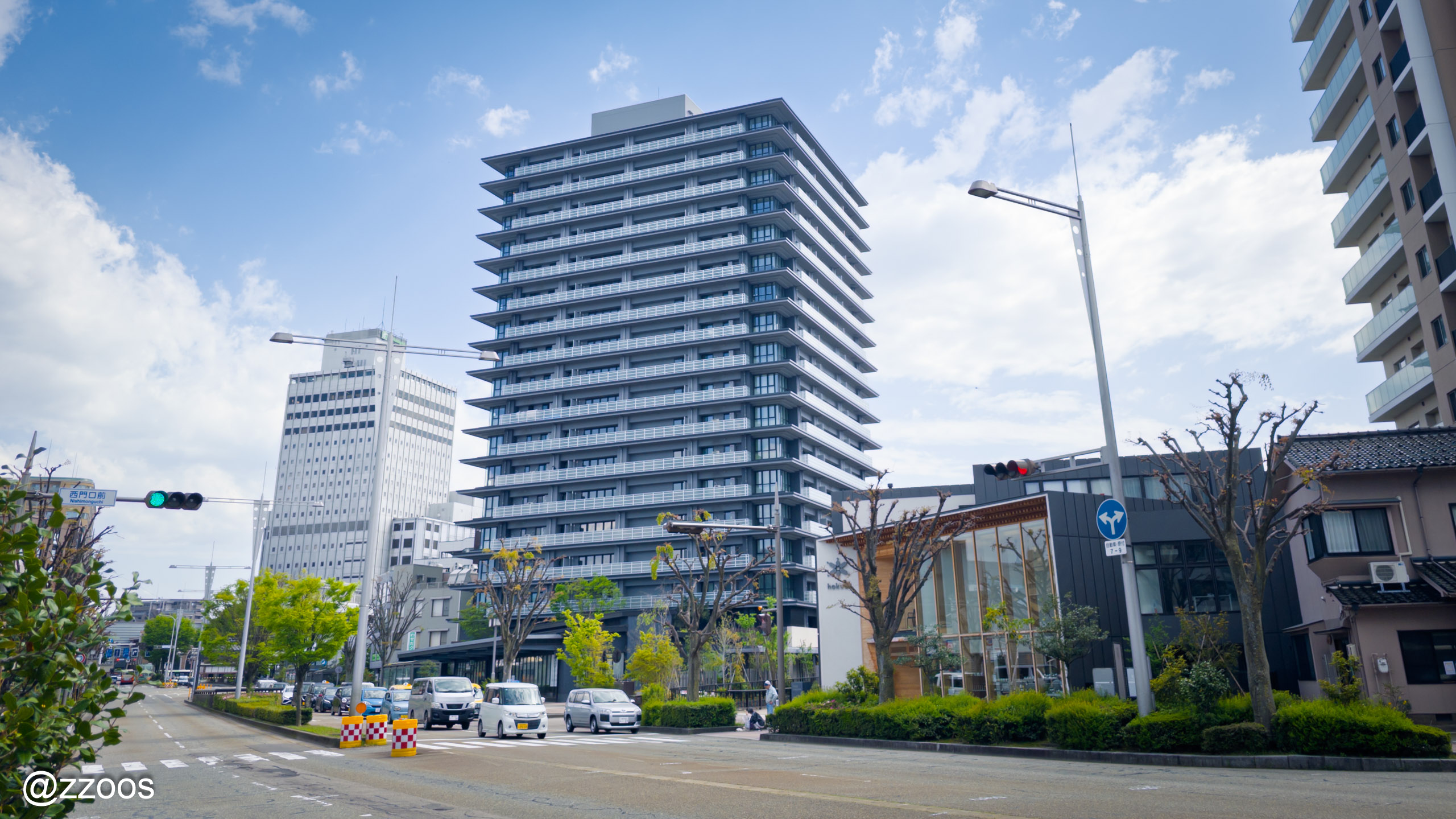 A clear-sky street view near Kanazawa Station with tall buildings