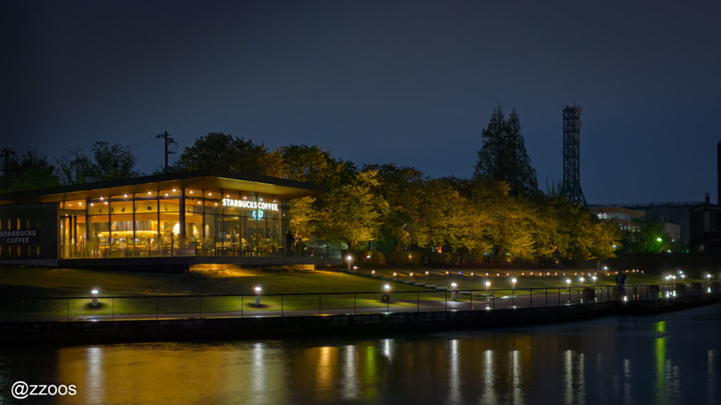 Night view of the Starbucks at Toyama Kansui Park next to the lake.