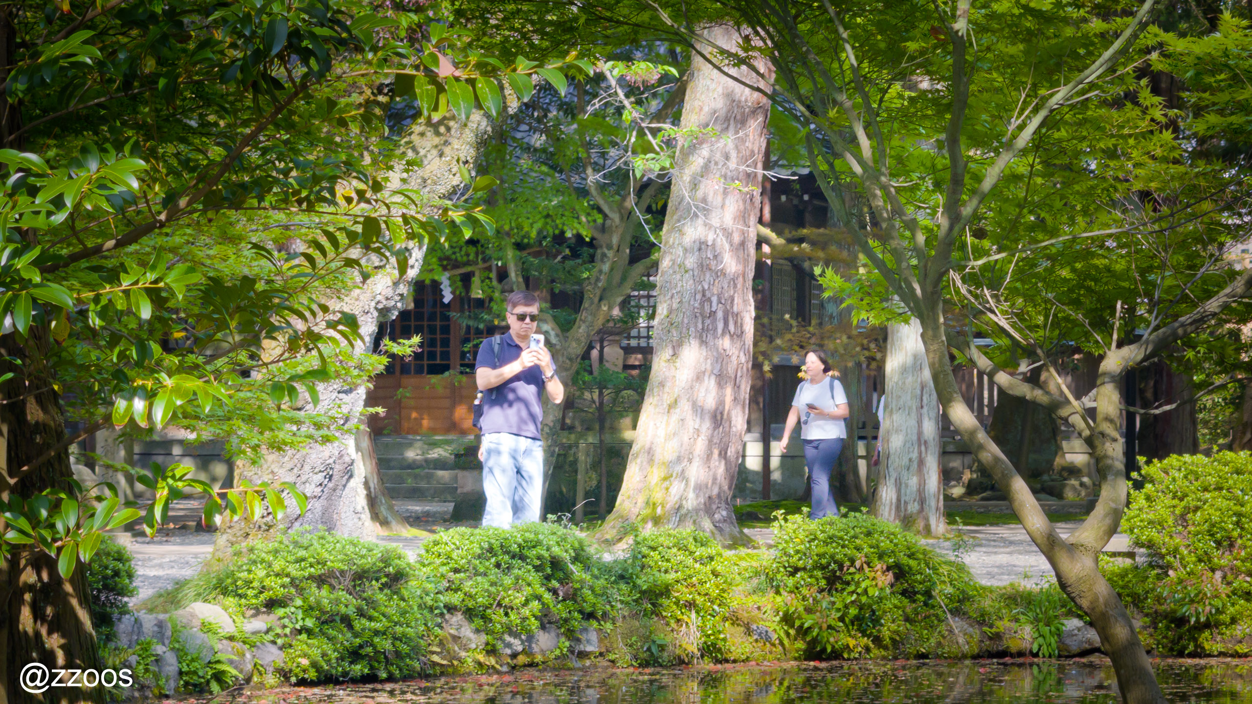 尾山神社で庭園を撮影している観光客