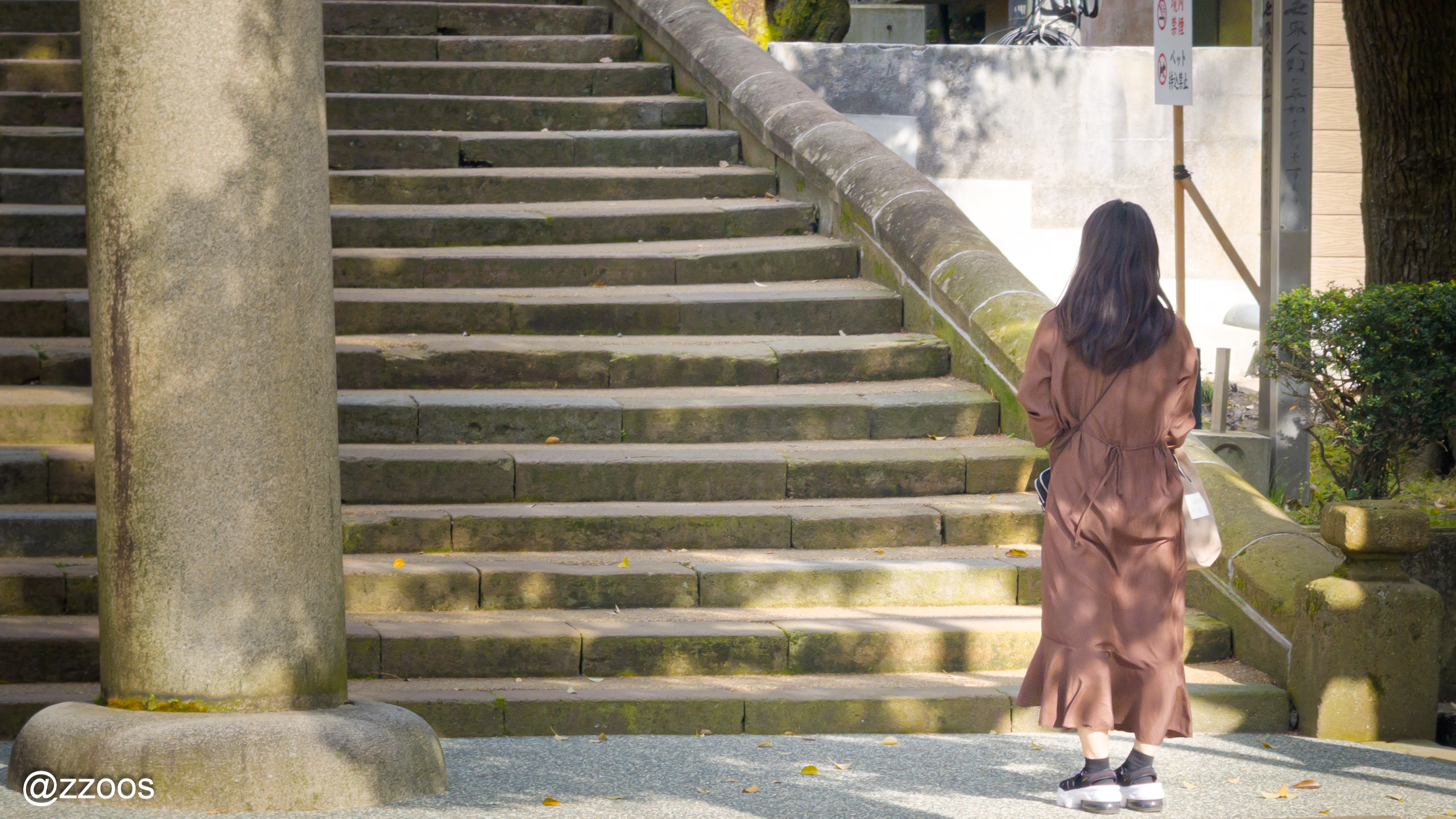 尾山神社の鳥居で振り返ってお辞儀をする参拝客
