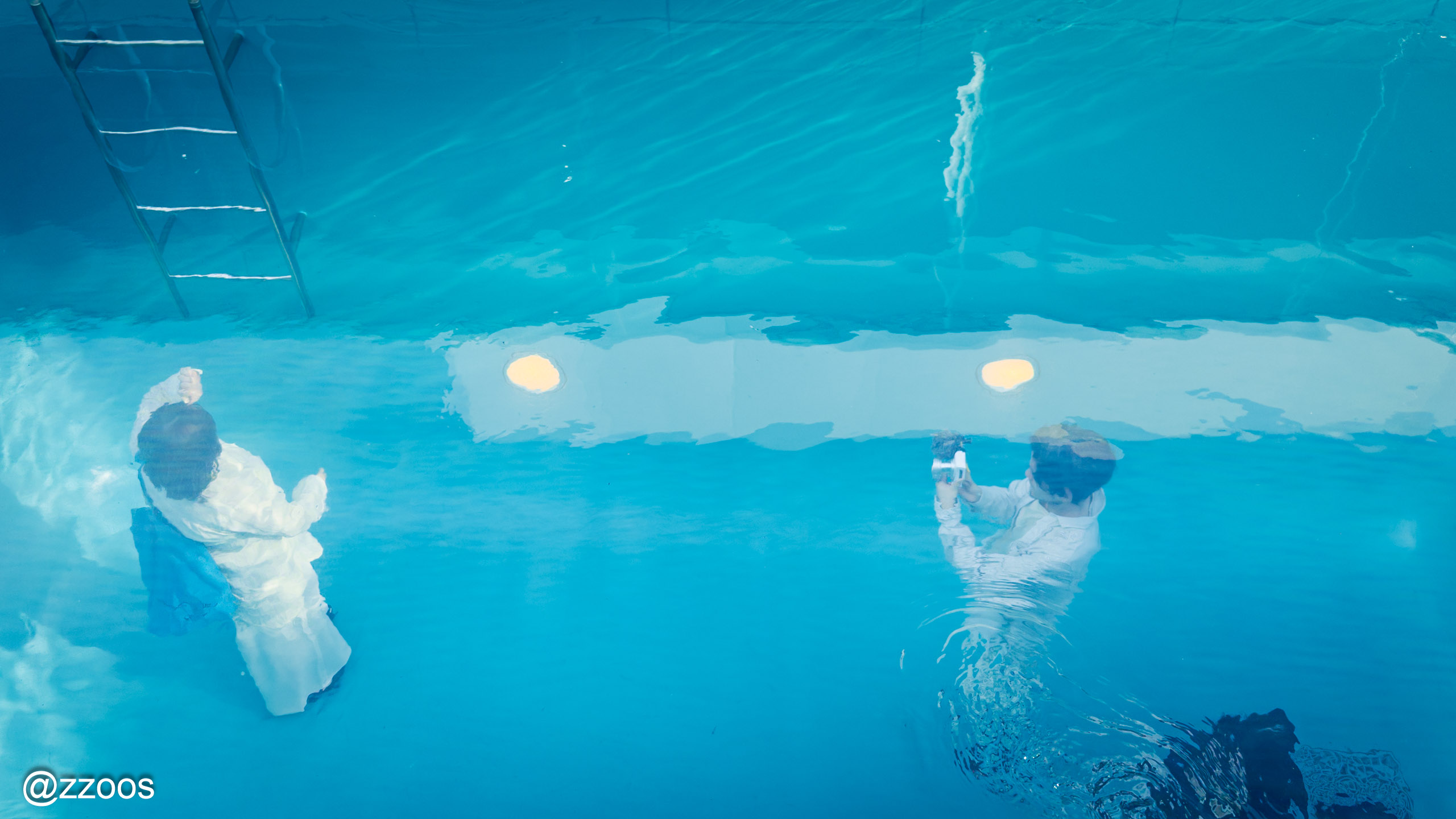 The Swimming Poolの水面上で水中にいるように見える来館者たち
