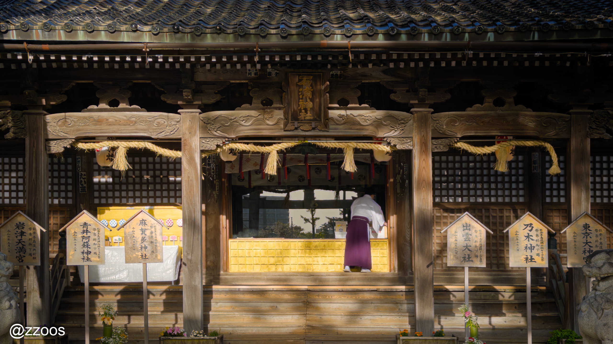 A shrine priest tidying up the haiden at Ishiura Shrine