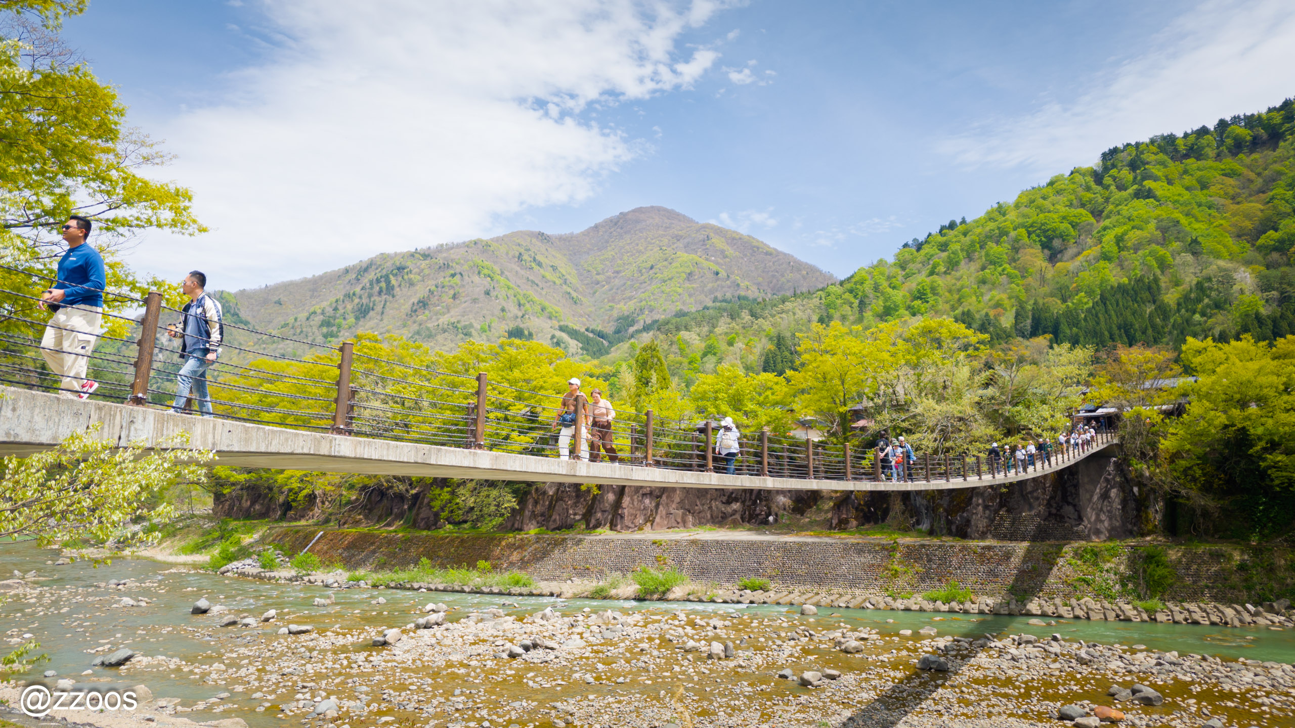 Tourists walking across Deai Bridge in Shirakawa-go