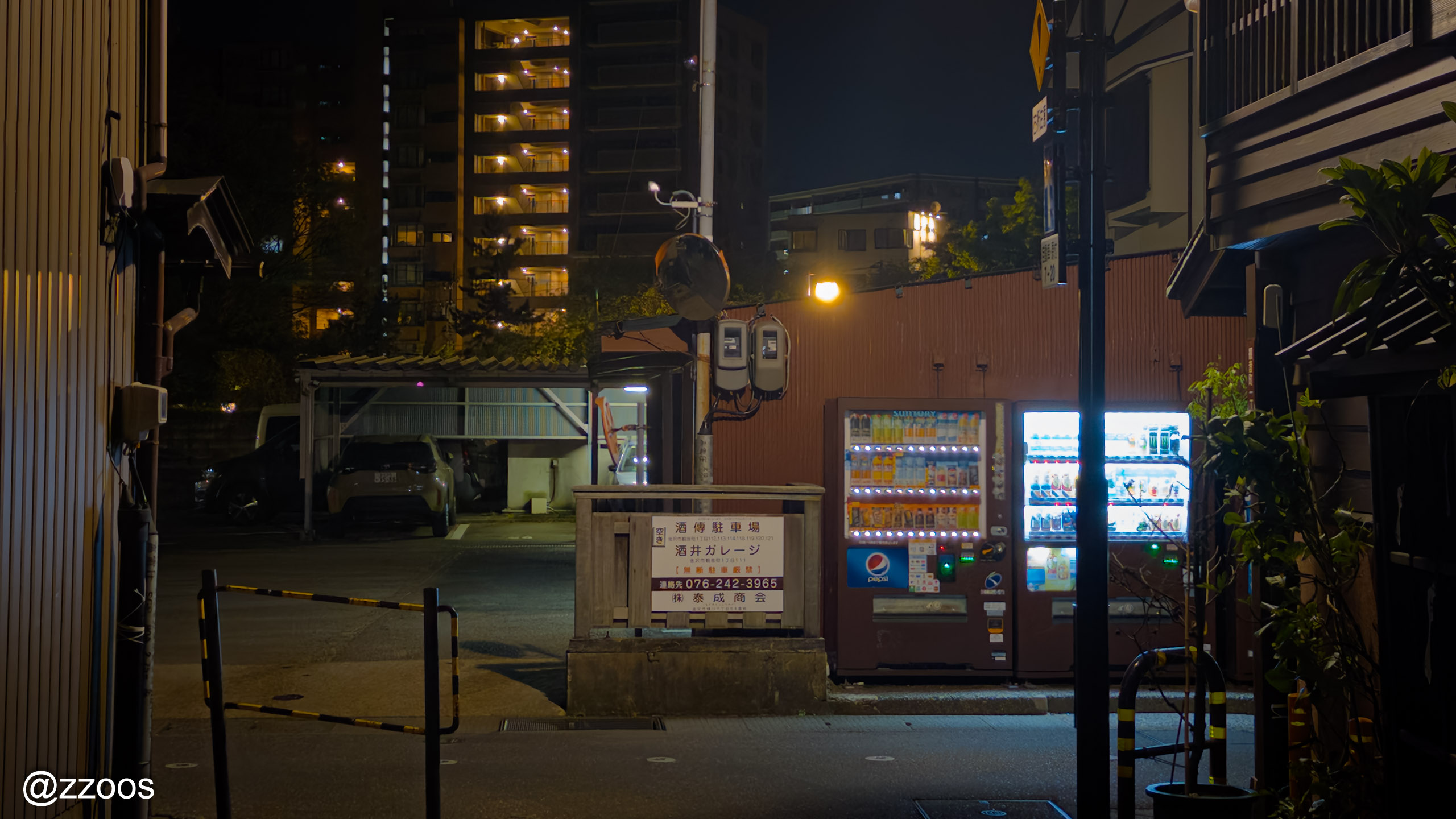 A vending machine and a parking lot at the end of the alley