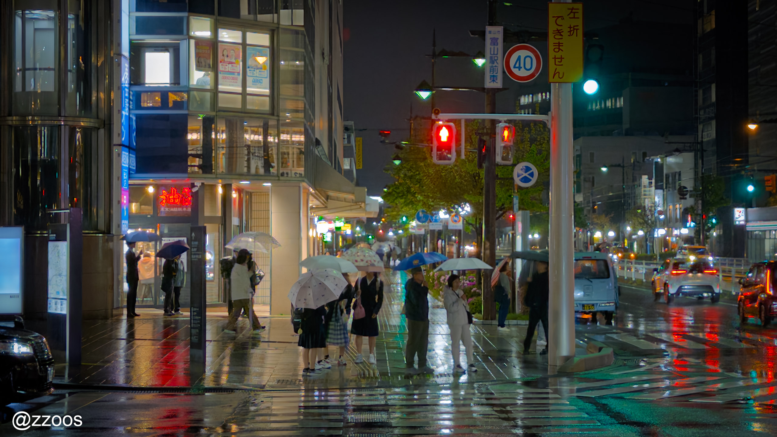 富山の雨の横断歩道で待つ人々