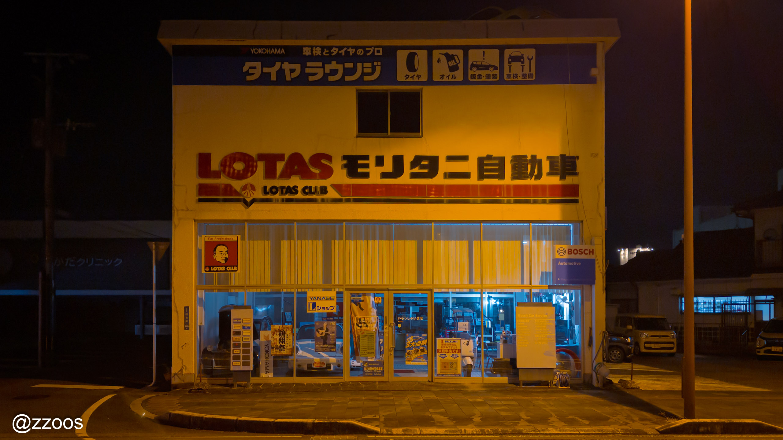 An auto repair shop in Izumi lit up at night