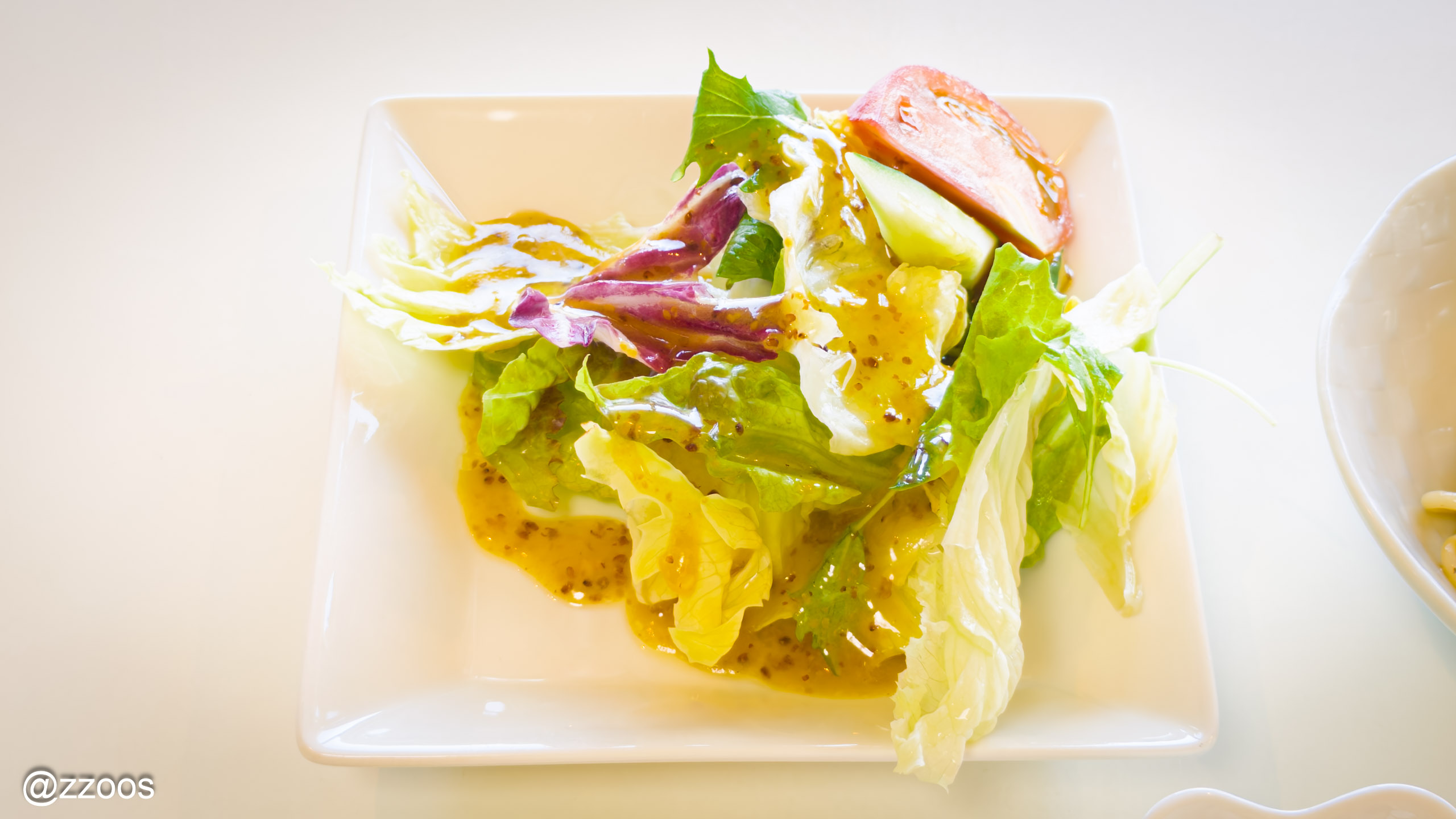 A green salad topped with peeled tomatoes