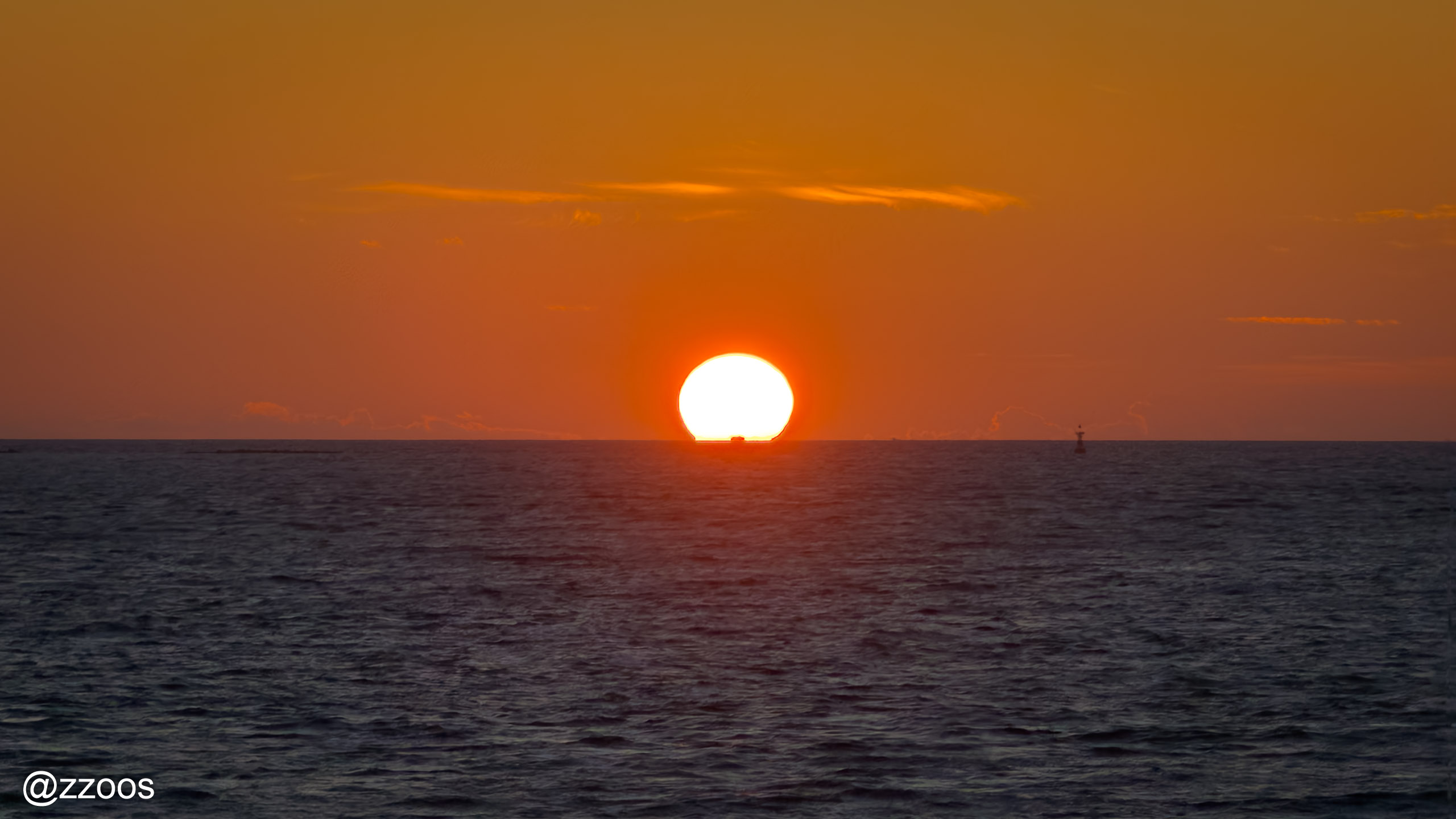 水面に沈む直前の太陽