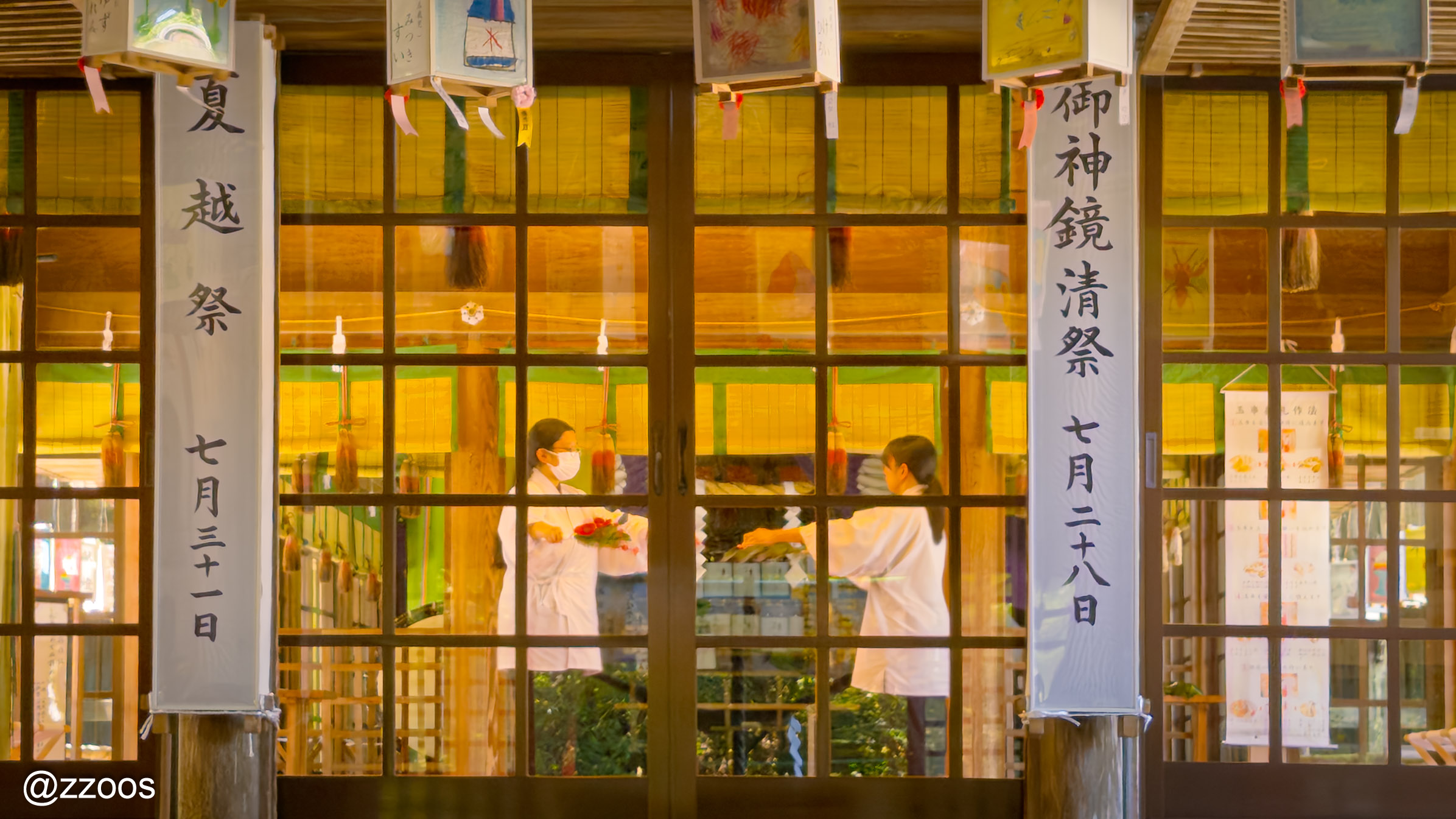 Two miko performing a rite at the haiden of Nitta Shrine