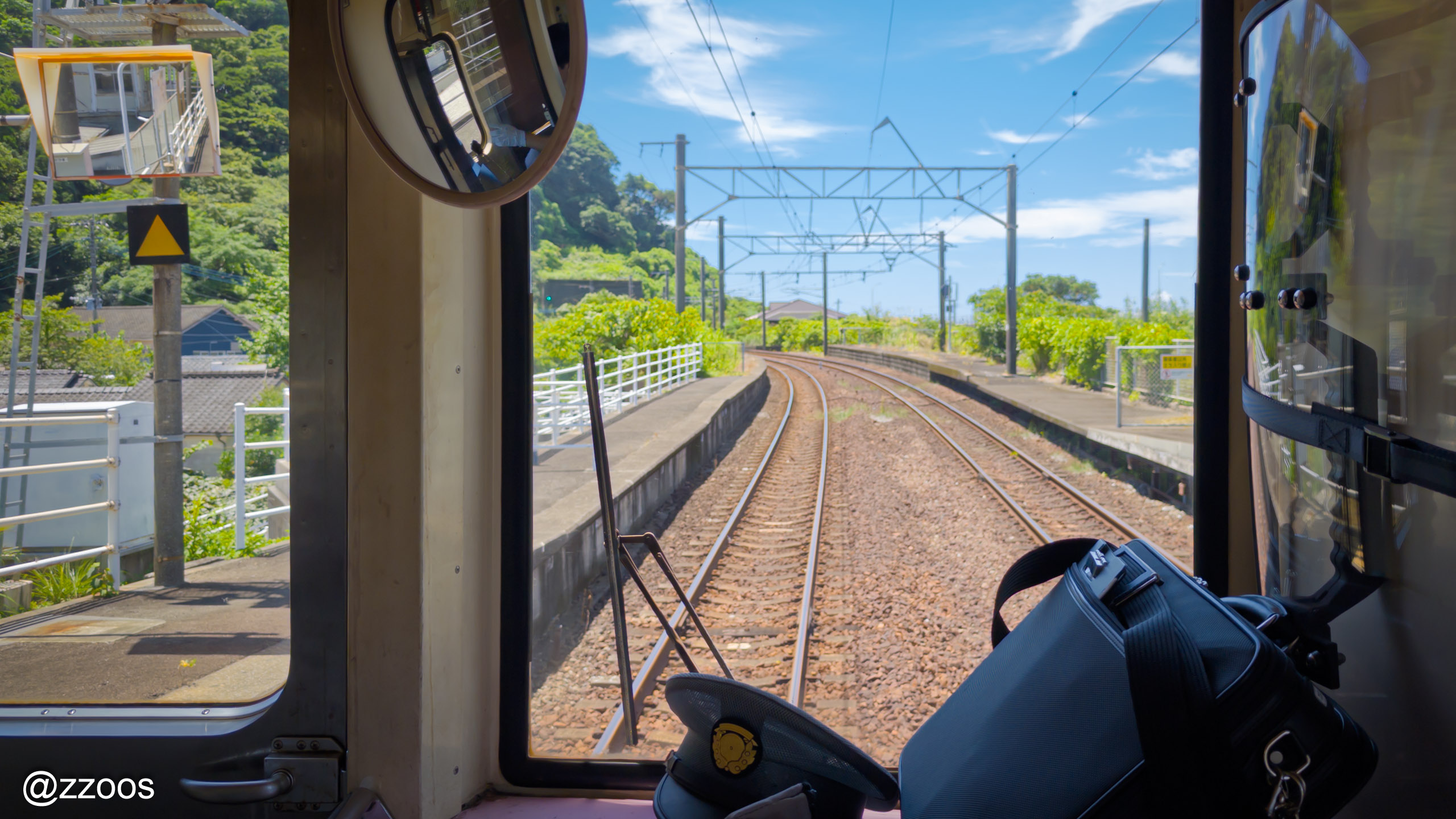 A Hisatsu Orange Railway train running between blue sky and greenery