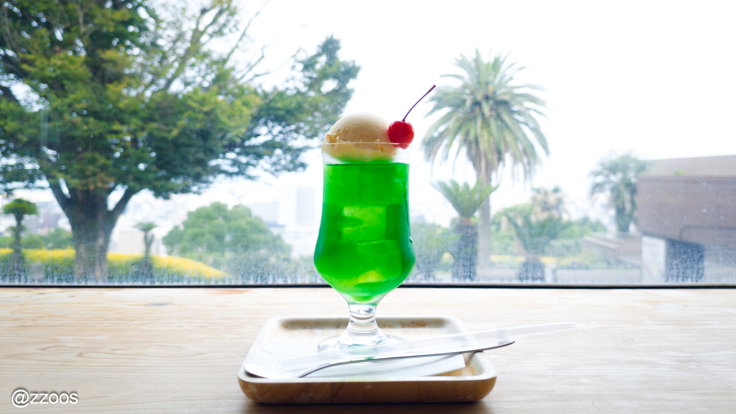 桜島と海を背景にしたメロンクリームソーダ