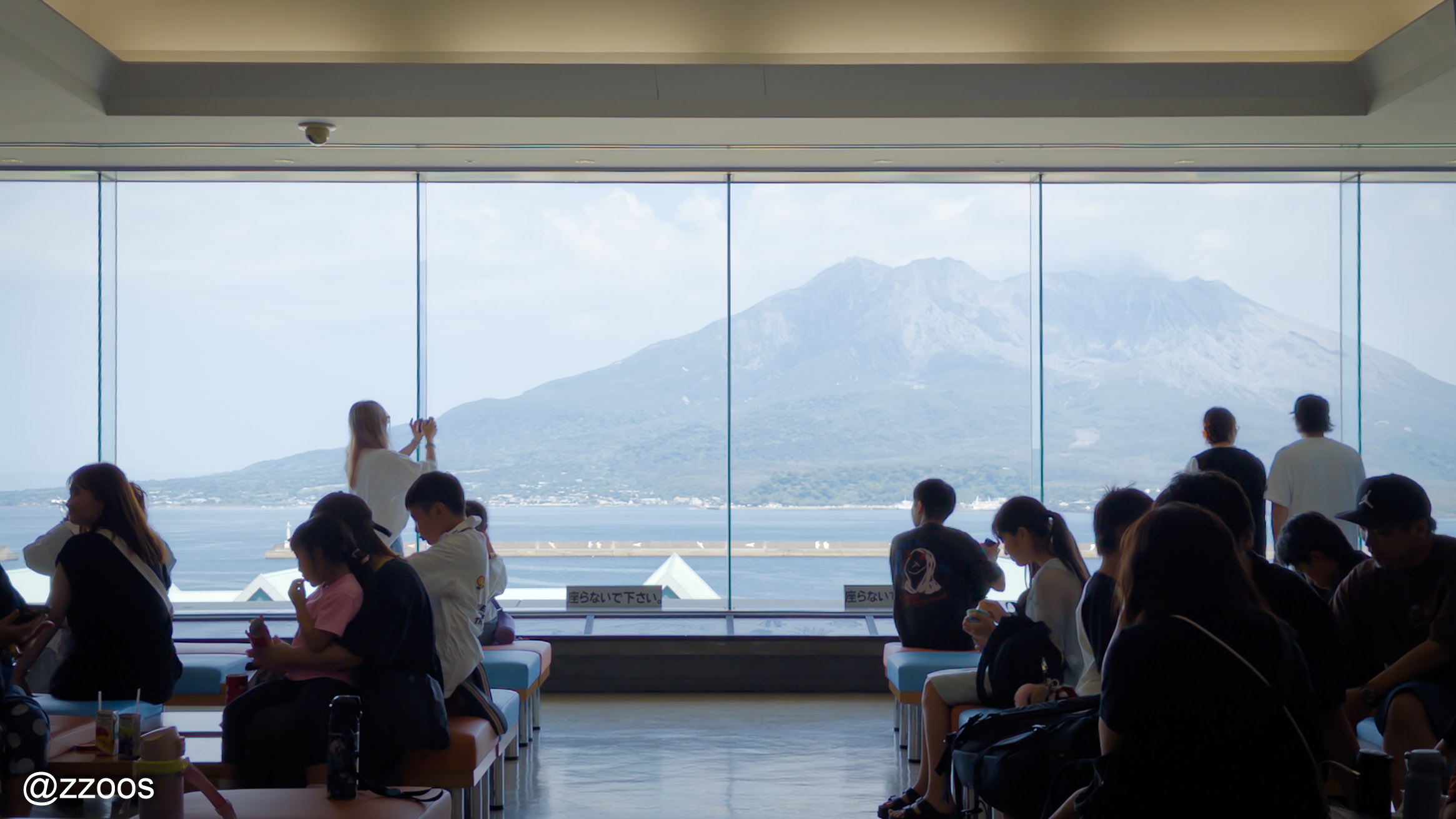 Fourth-floor lounge of Kagoshima City Aquarium with Sakurajima visible through the window