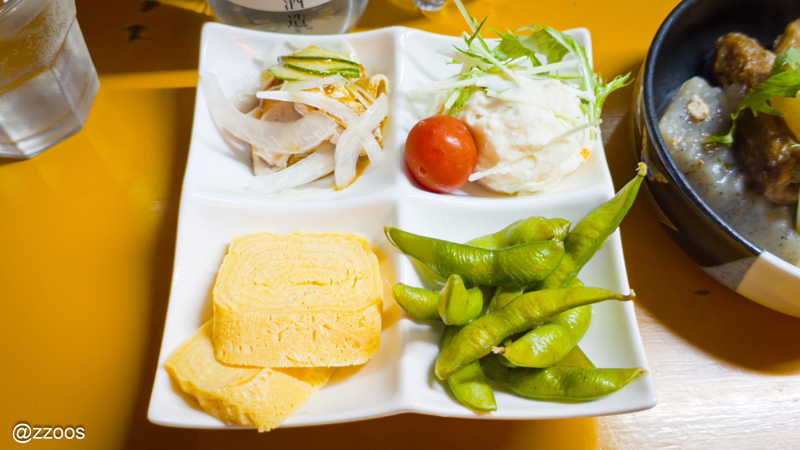 A plate of torisashi, potesara, tamagoyaki, and edamame